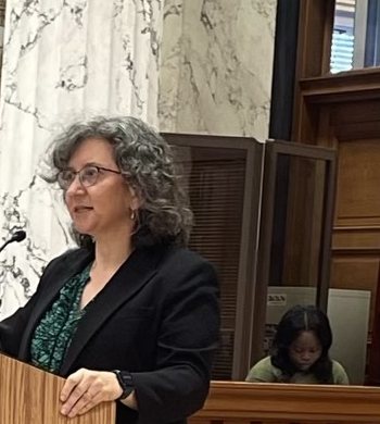 Elizabeth Lower-Basch speaking at a podium in the
                  Mississippi State Capitol